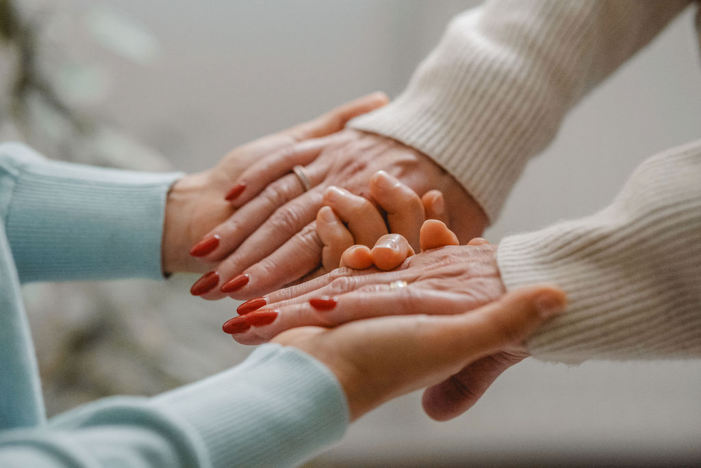 nahaufnahme von melli seedorf ihren händen, wie sie die hände einer klientin sanft hält